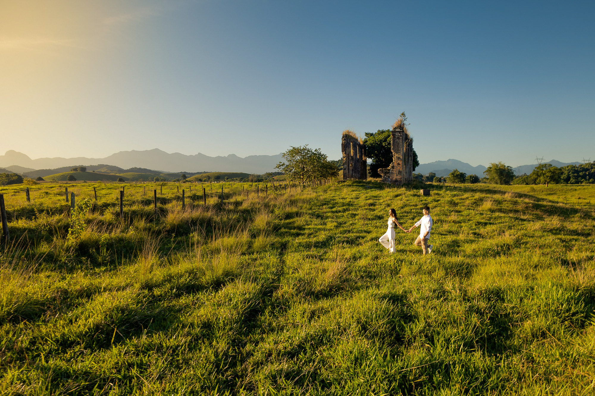 Casal caminhando no campo durante o pré-wedding